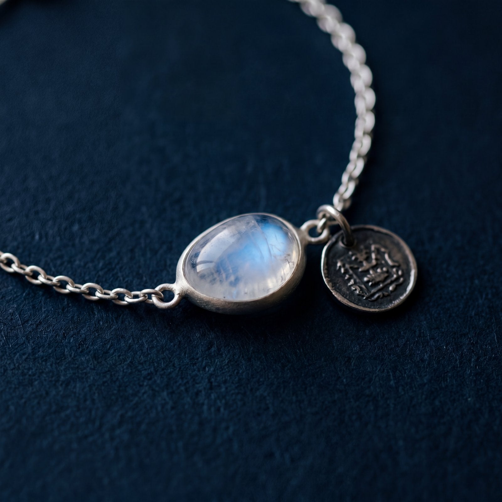 Moonstone and engraved coin charm bracelet macro