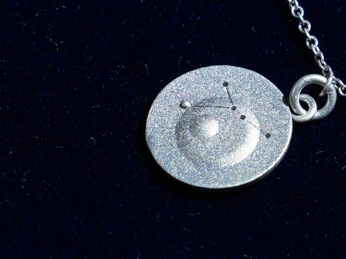 The Cancer coin, engraved with the constellation, close up