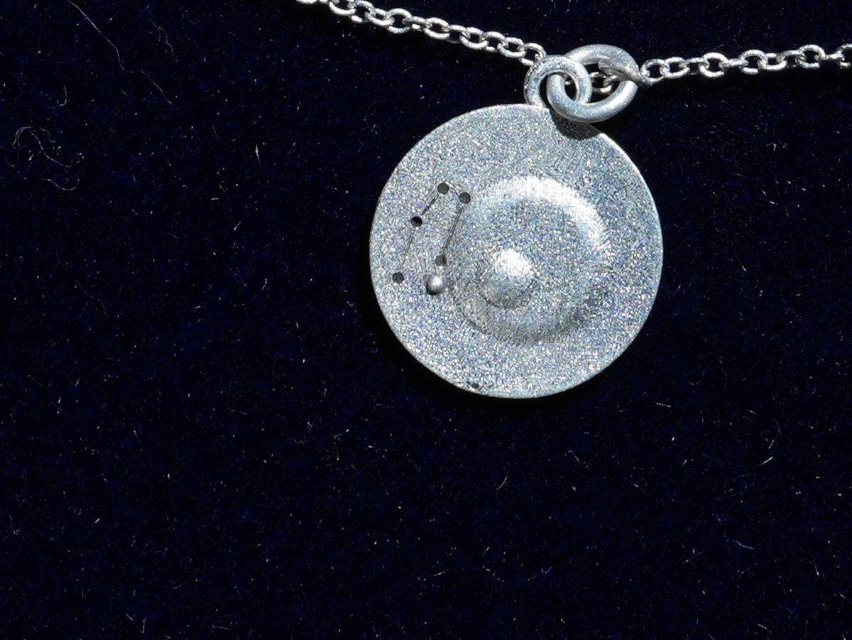 The Gemini coin, engraved with the constellation, close up