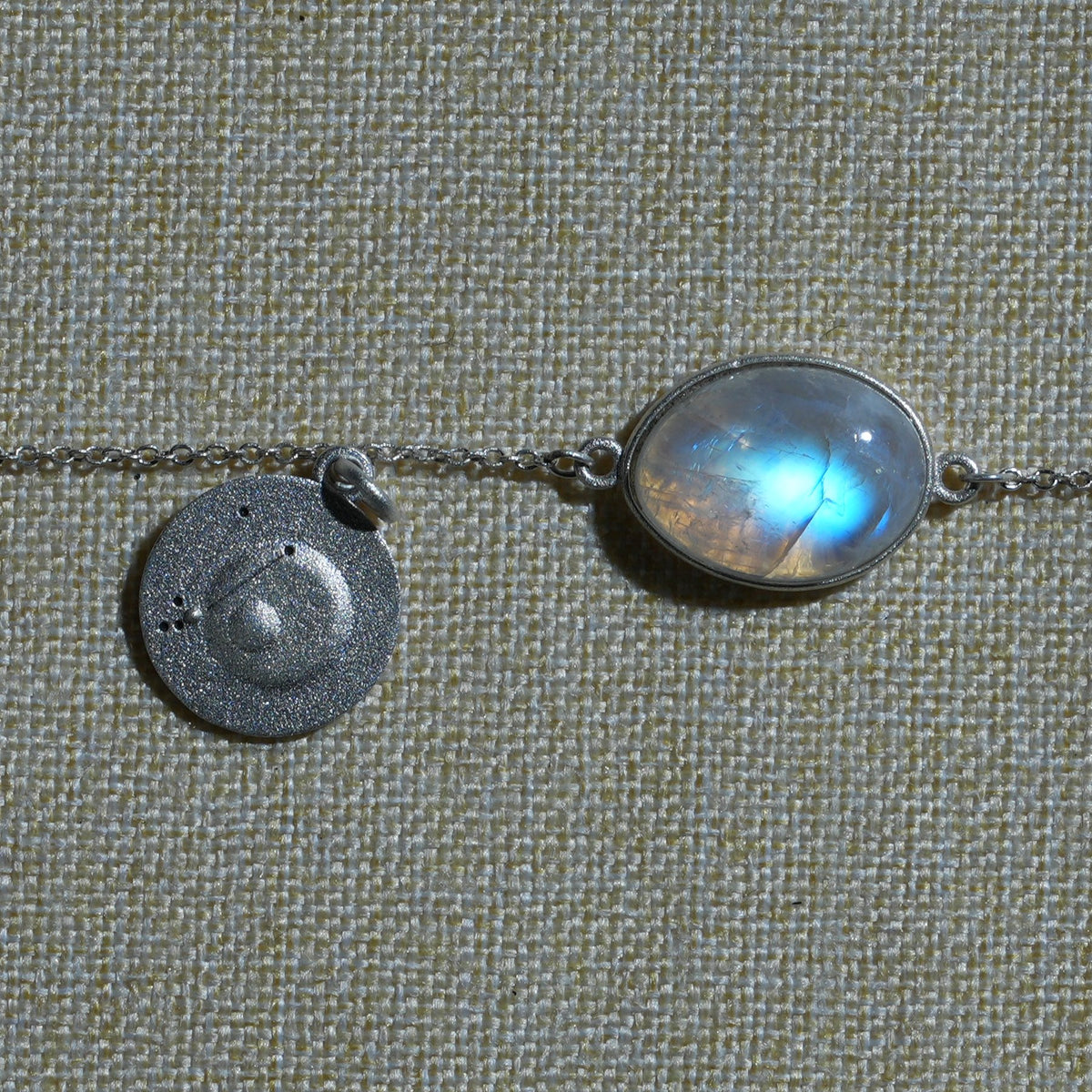 A moonstone bracelet on natural linen, close up
