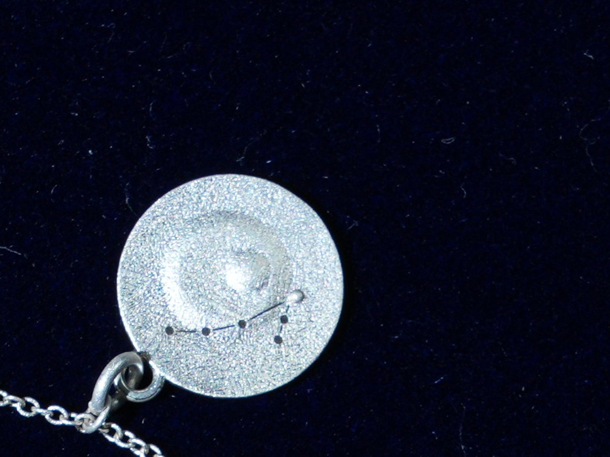 The Pisces coin, engraved with the constellation, close up