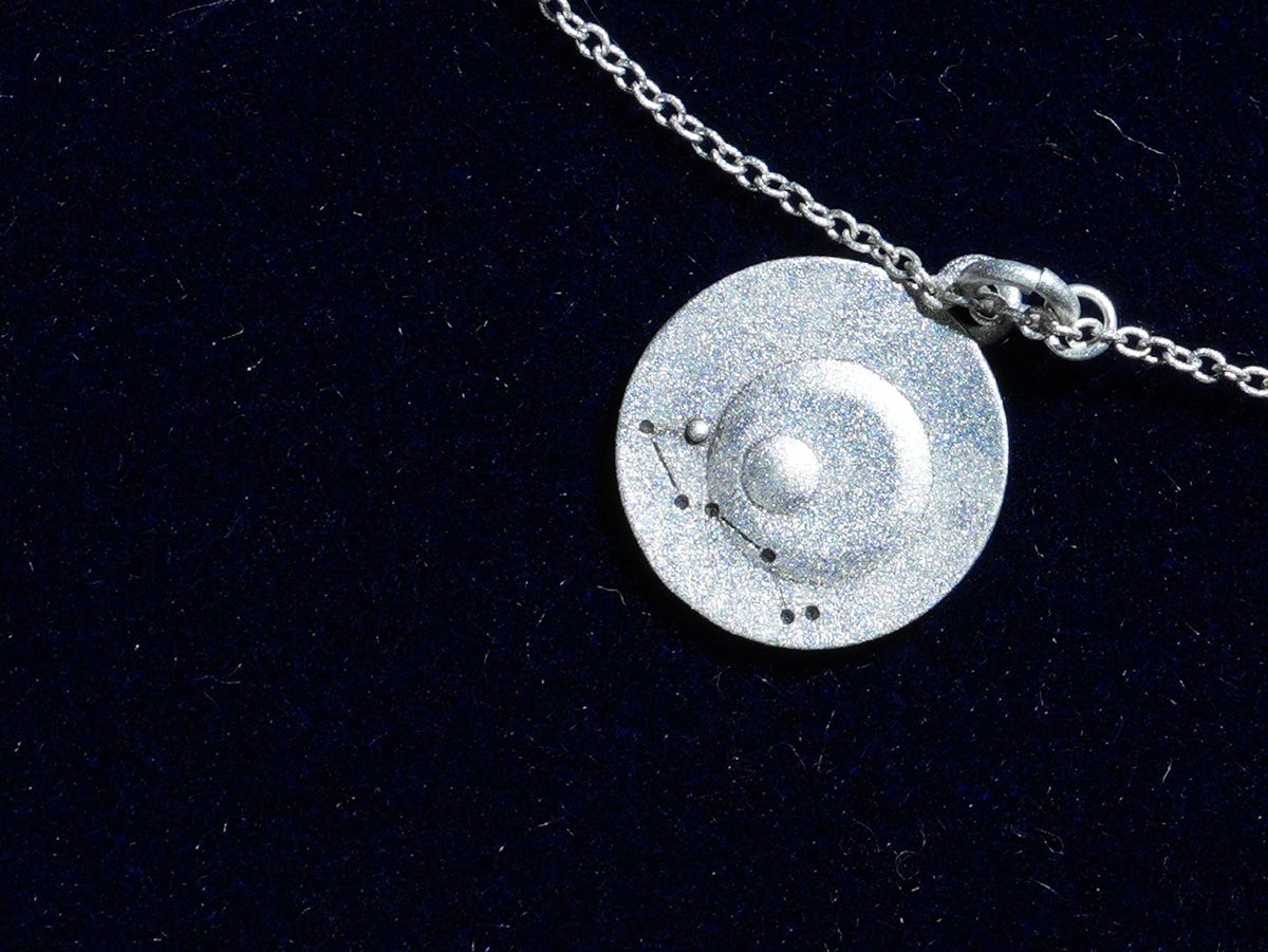 The Scorpio coin, engraved with the constellation, close up
