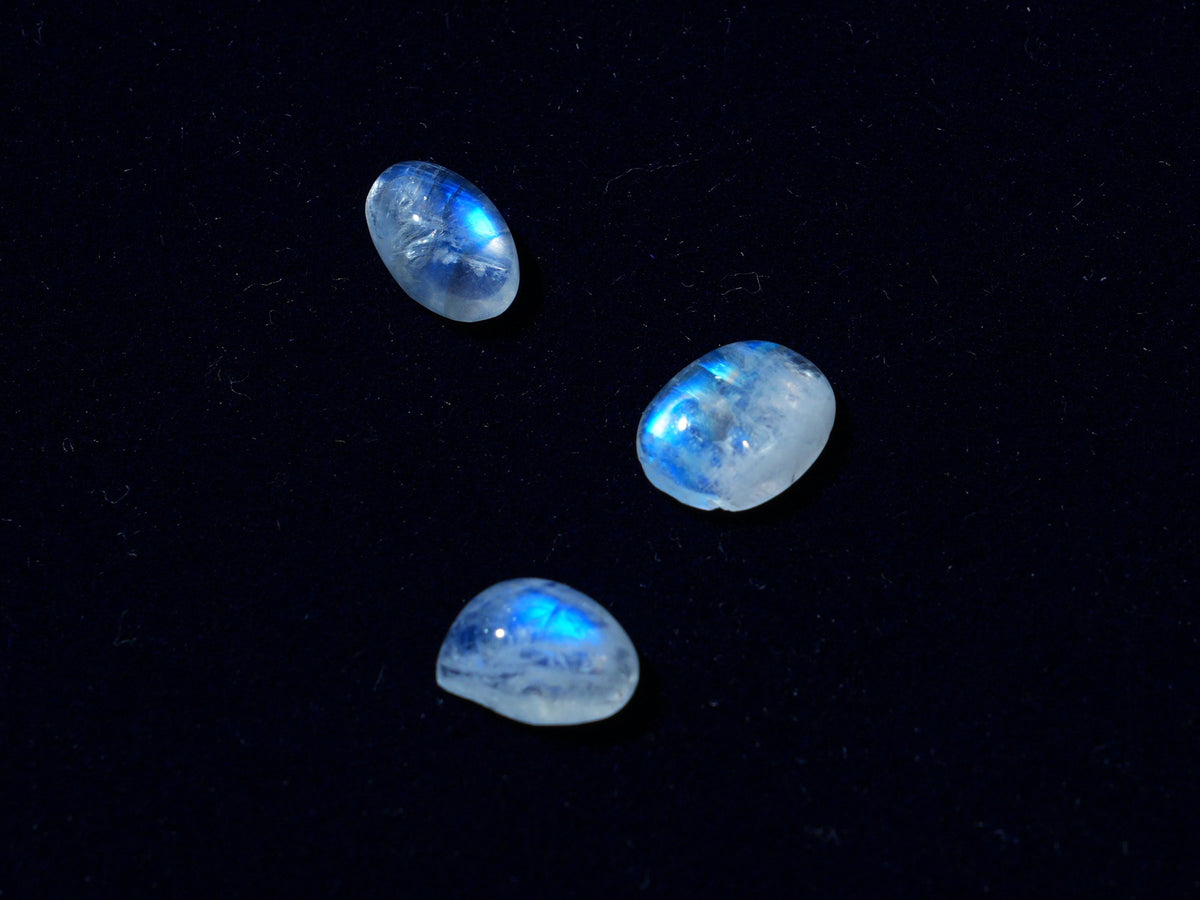 Three moonstones on navy velvet