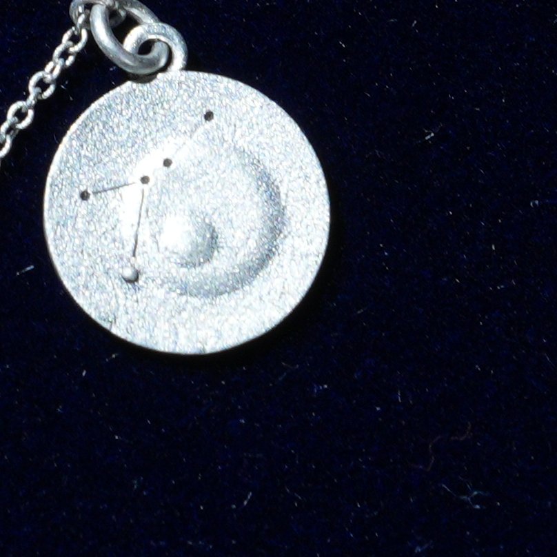 Coin of AV-0004, engraved with the Cancer constellation, close up