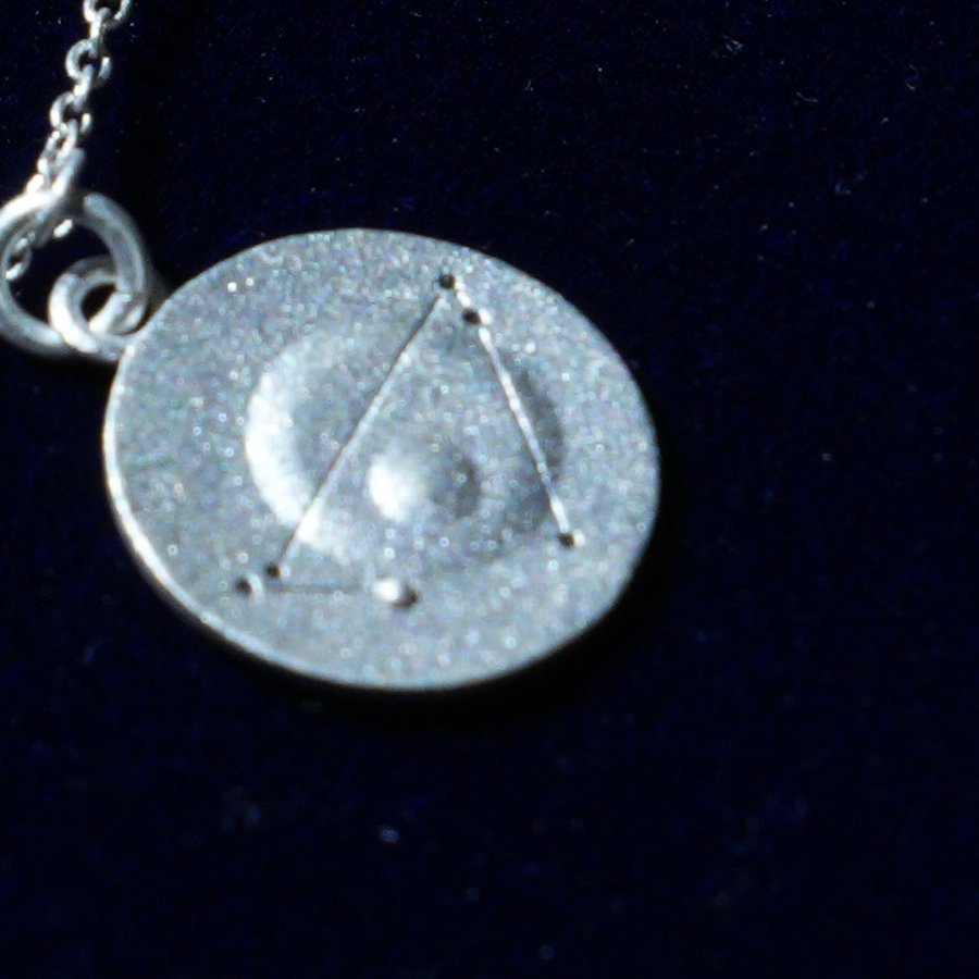 Coin of AV-0034, engraved with the Capricorn constellation, close up