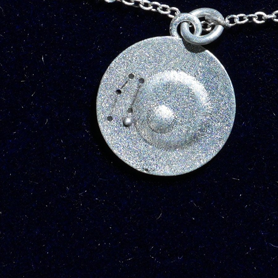 Coin of AV-0024, engraved with the Gemini constellation, close up