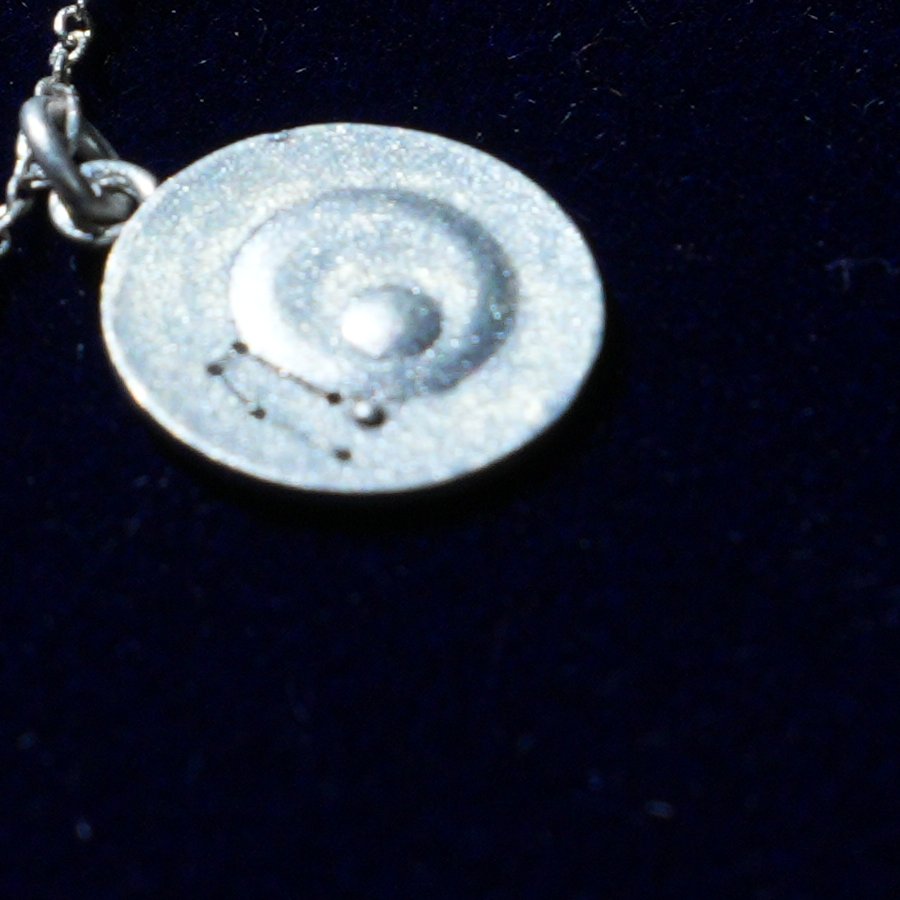 Coin of AV-0039, engraved with the Gemini constellation, close up