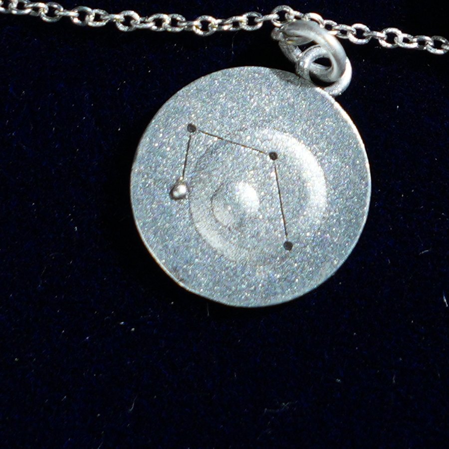 Coin of AV-0007, engraved with the Libra constellation, close up