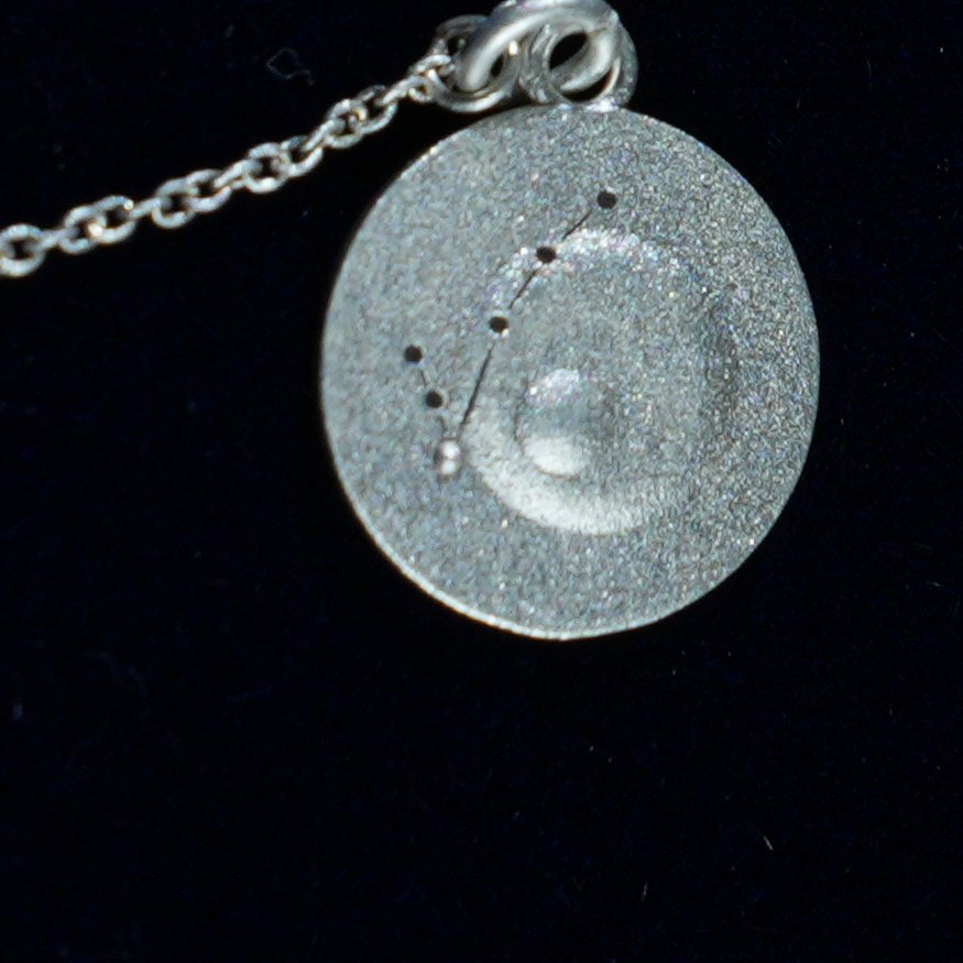 Coin of AV-0012, engraved with the Pisces constellation, close up
