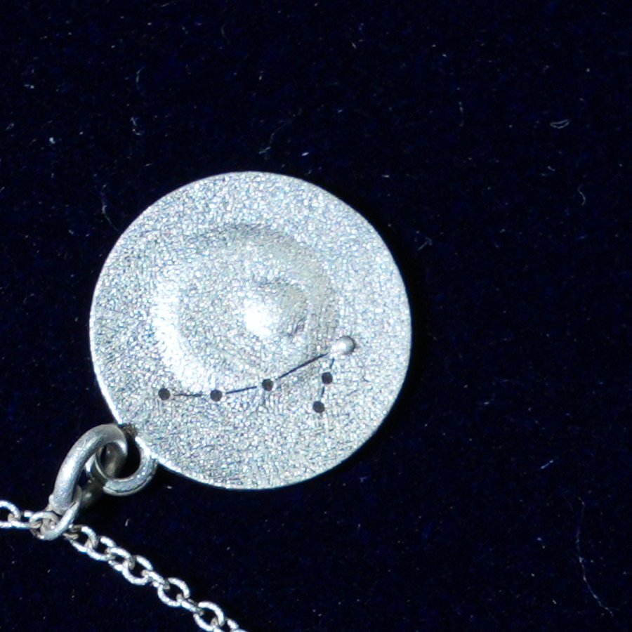 Coin of AV-0013, engraved with the Pisces constellation, close up
