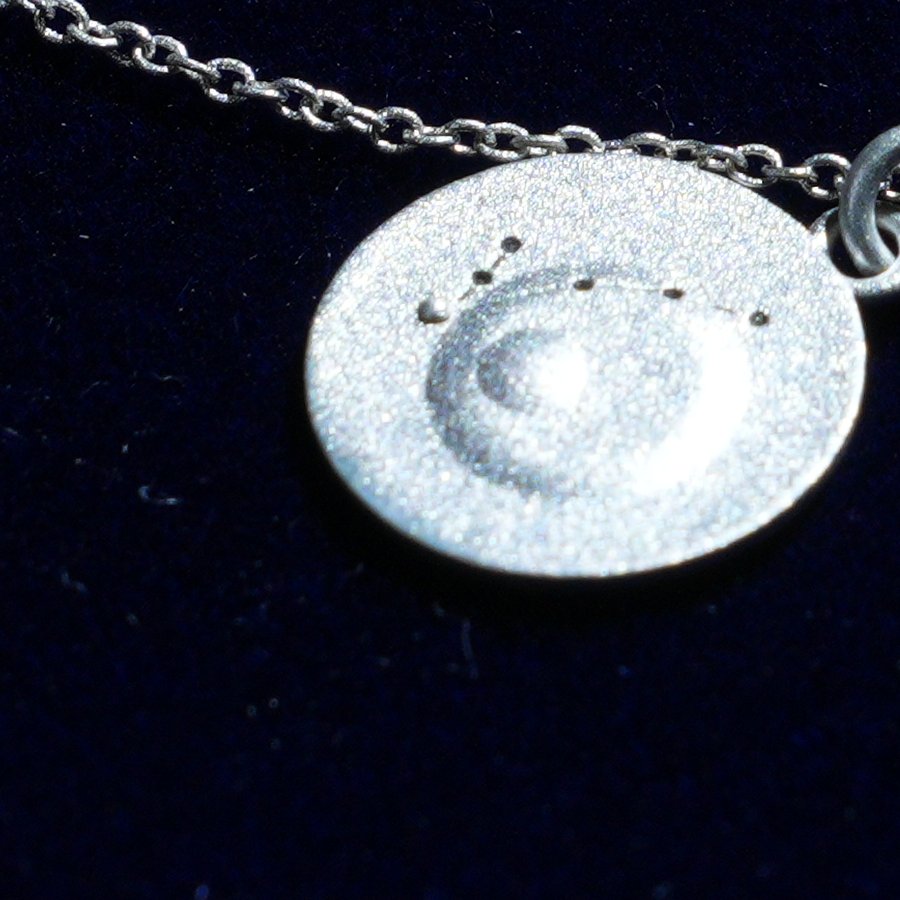 Coin of AV-0032, engraved with the Pisces constellation, close up