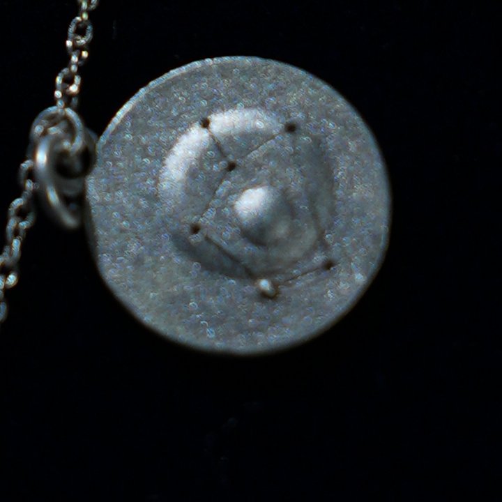 Coin of AV-0009, engraved with the Sagittarius constellation, close up